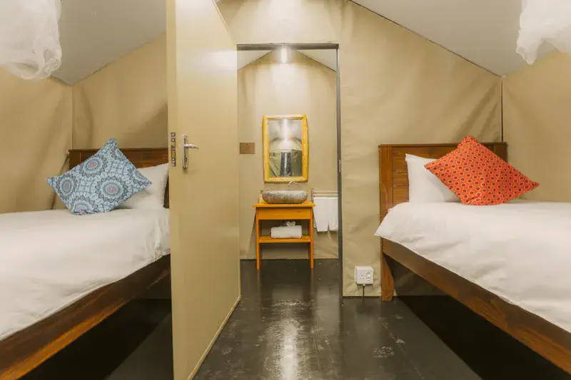 Two timber single beds with white linen and a small table between them